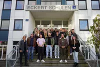 Wirtschaftsfachwirt Kursstart 12 2025 Eine Gruppe von rund zwanzig angehenden Wirtschaftsfachwirten steht auf der Treppe vor dem Haupteingang der Eckert Schulen in Regensburg und lächelt in die Kamera.