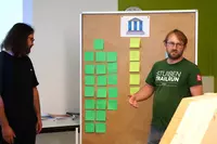 Ein angehender Bautechniker präsentiert seine Ergebnisse zum Thema nachhaltiges Bauen.