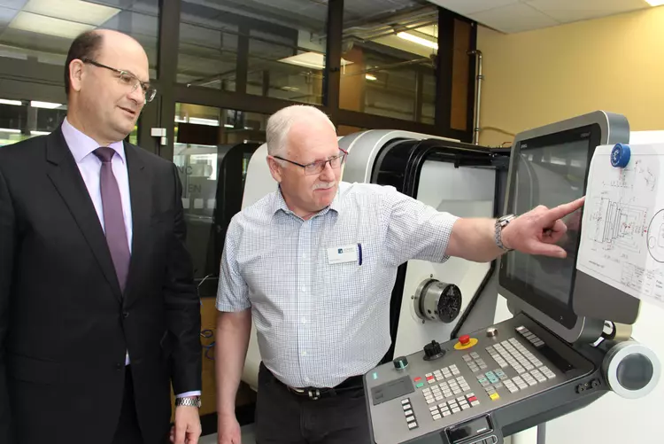 Bayerns Heimatstaatssekretär Albert Füracker informierte sich bei einem Campusrundgang an den Eckert Schulen in Regenstauf über die praktischen Inhalte der Techniker-Weiterbildungen. Das Bild zeigt ihn an einer hochmodernen CNC-Fräsmaschine.