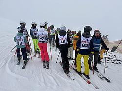 Teilnehmende der Rotaryskimeisterschaft auf der Piste - darunter Kinder und Erwachsene auf den Ski. Startklar, jedoch bei starkem Nebel. 