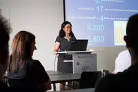 Frau Hua Lei von Eckert Schools International hält den Vortrag zum China-Austauschprogramm. Im Hintergrund ist eine Präsentationsfolie mit Zahlen und Fakten zu China zu sehen.