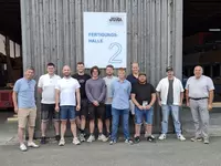 Studierende des zweiten Semesters der Holztechnikerweiterbildung erhalten bei JURA-Holzbau Einblicke in die Fertigung moderner Holzhäuser.