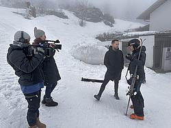 Teilnehmende der Rotaryskimeisterschaft werden draußen im Schnee und bei Nebel interviewt.